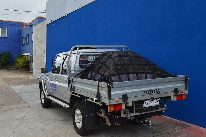 Your essential guide to cargo nets on a Toyota truck with cargo netting over the bed.